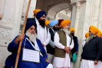 Sukhbir Badal reached Golden Temple on a wheelchair with a placard aro...